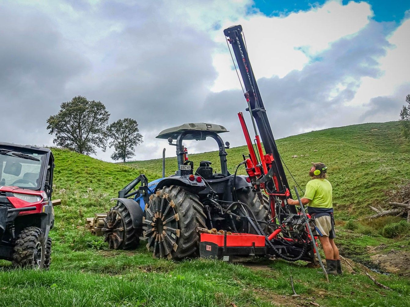 Farmer operating FencePro Ultra G2 post driver mounted on SM900 Sidemount Base