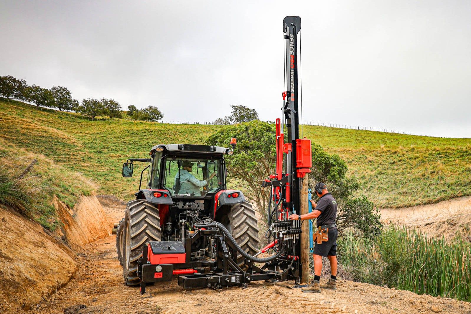 Fencing contractor using a FencePro PB650 in side mount position, post driver balanced with the suitcase counterweight system.