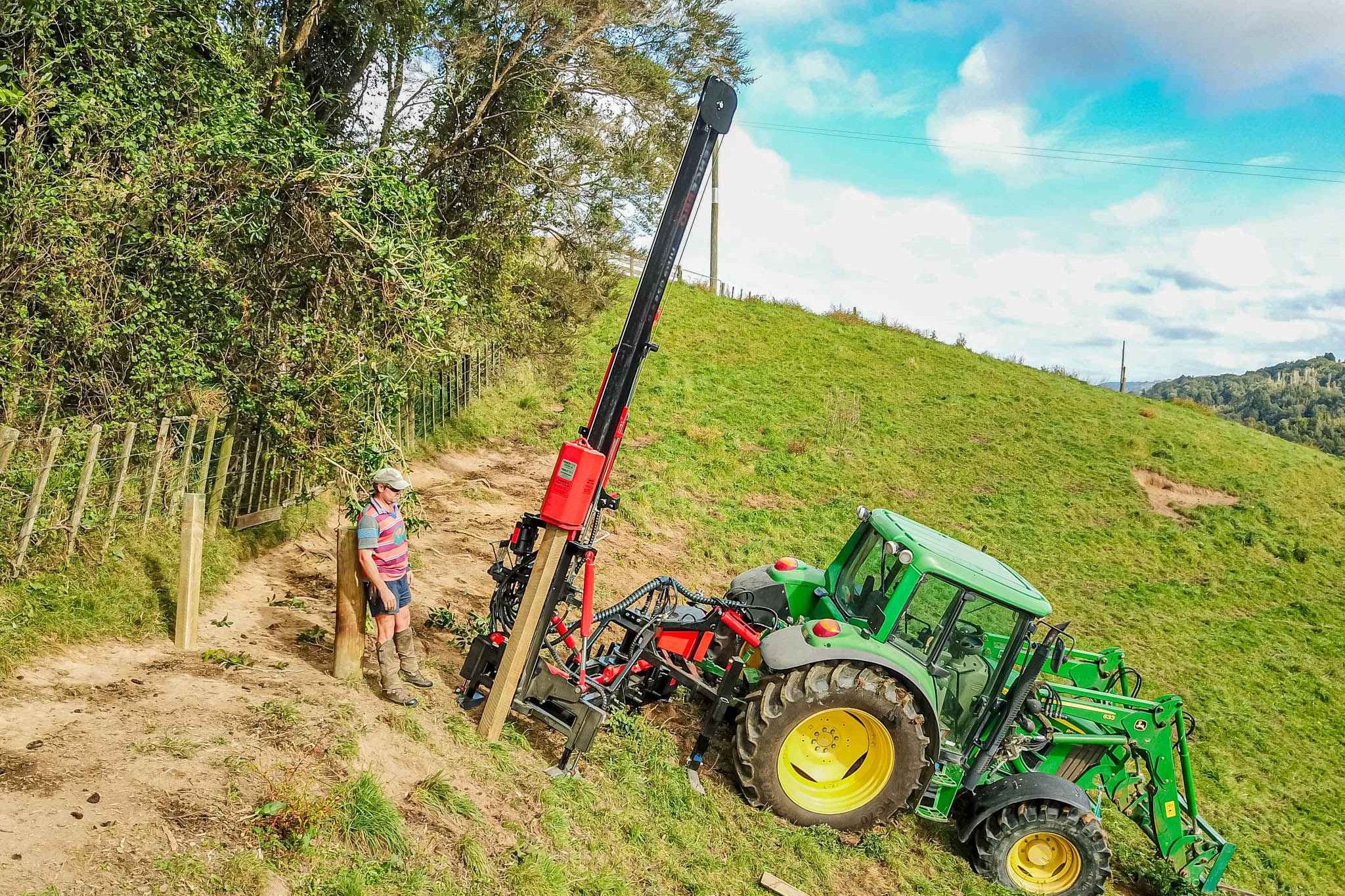 FencePro Ultra G2S post driver with 180° rotational base installing fence posts on steep hill country