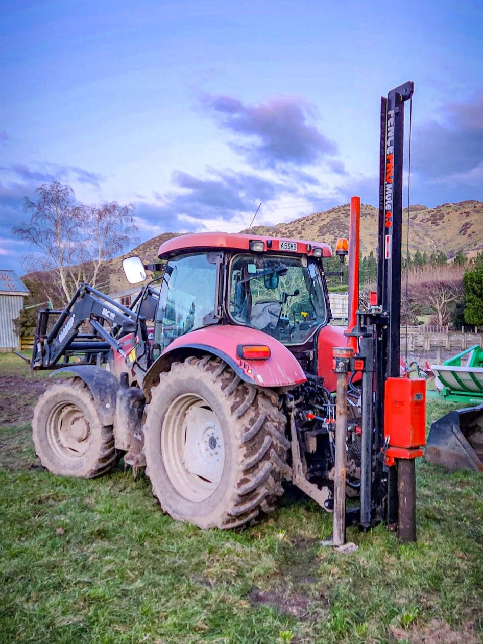 FencePro Mule post driver ramming a fence post into a pilot hole made with the Rockspike.