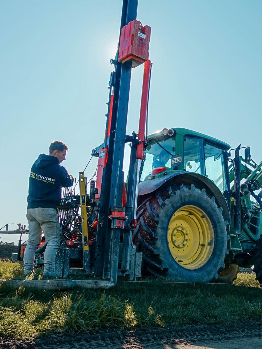 Fencing contractor operating near-side hydraulically positioned FencePro UltraGlide rockspike kit on tractor, demonstrating smooth operation with plastic slides on rigid square column