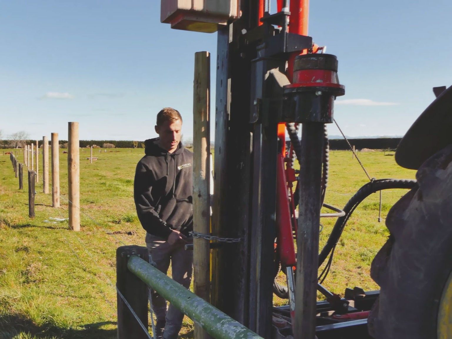 a South Island fencing contractor using the pin & chain to hold a post firmly against the FencePro Ultra G4 hydraulic post driver mast.