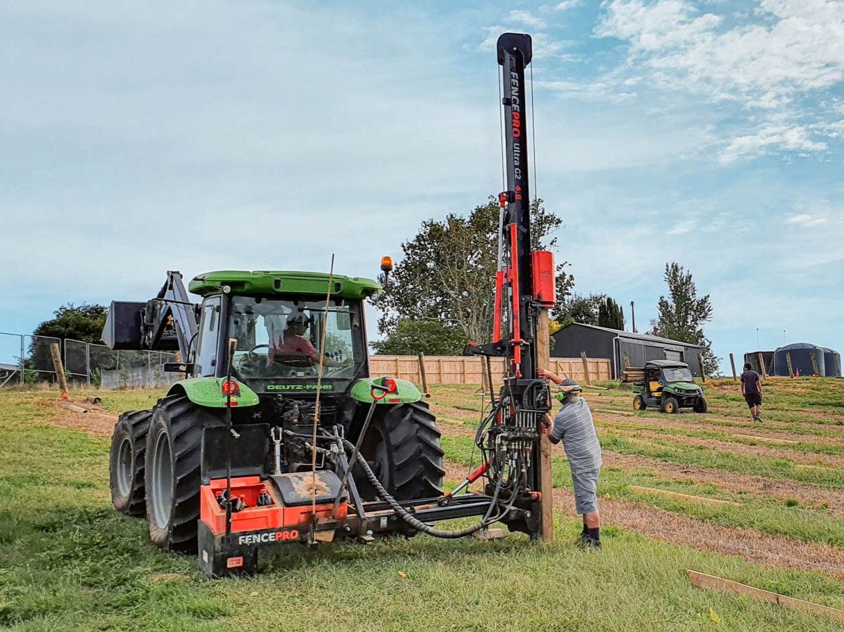 Post driver on FencePro SM900 Sidemount Base positioned at fence line, featuring twin lockable toolboxes for secure tool storage