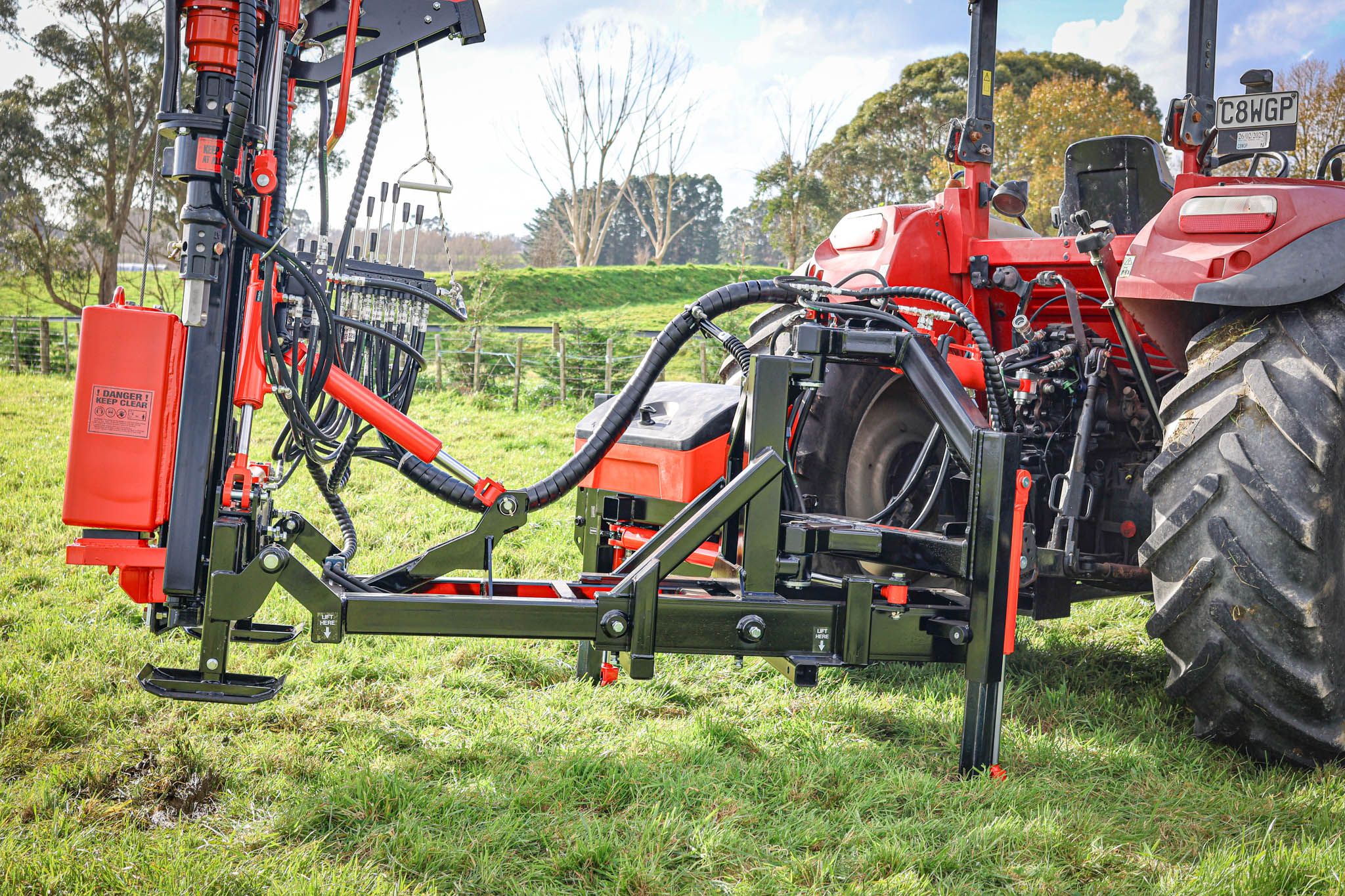 FencePro PB650 base rotated to its full 130° around the back of the tractor, showing the plastic slides, hydraulic legs, and strengthening gussets.