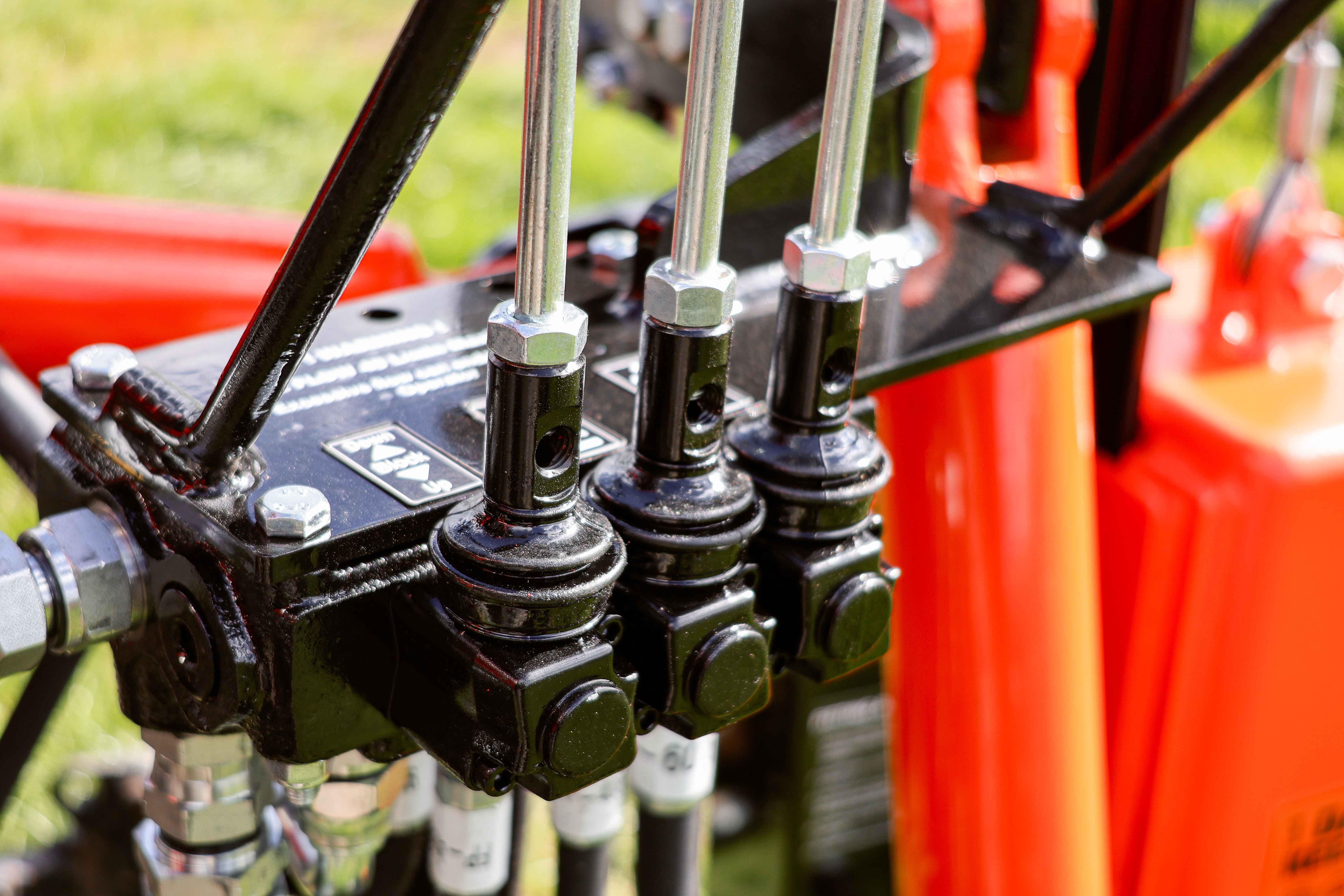 FencePro Farmtek post driver hydraulic valve bank with three-function control levers for precision fencing