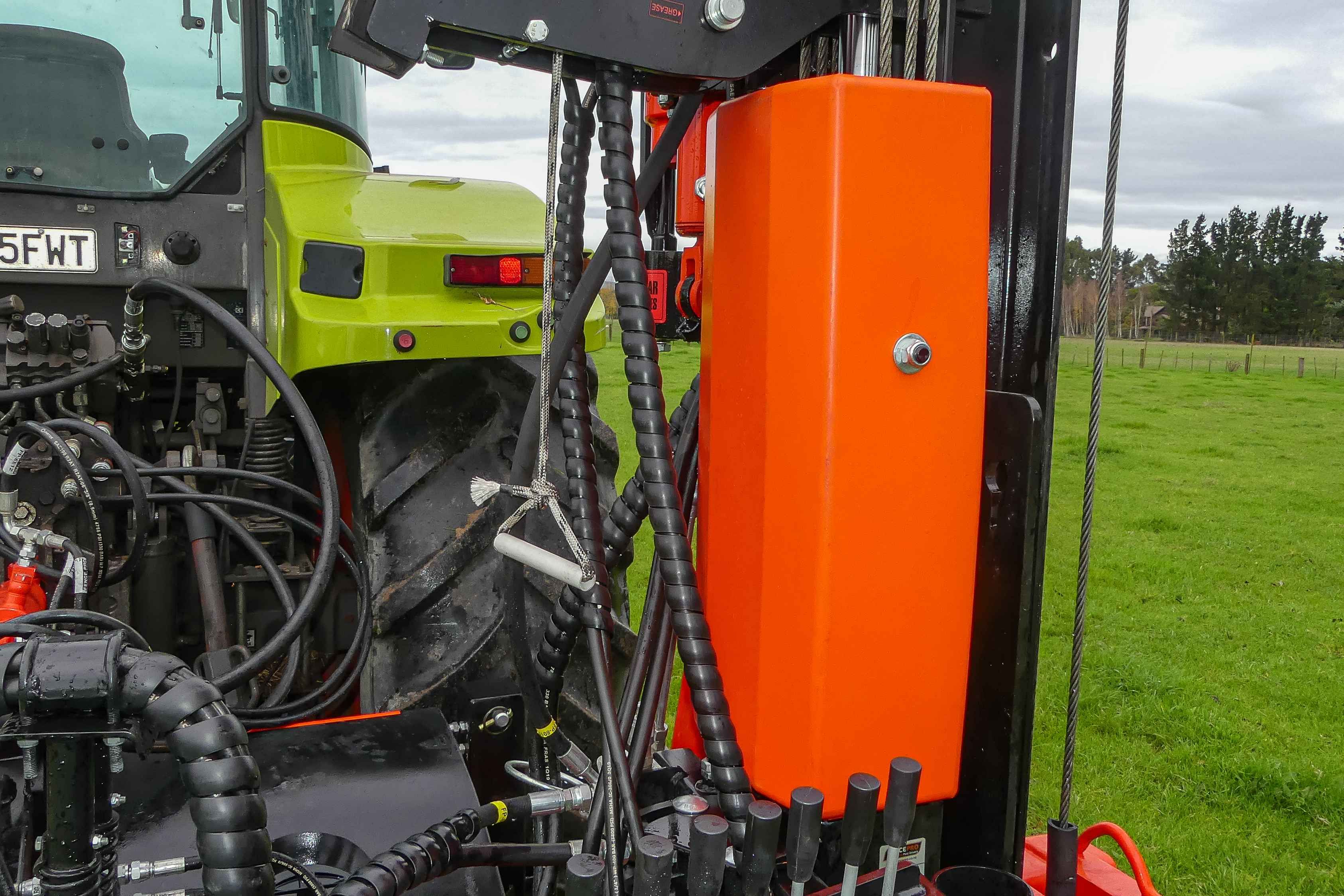 Close-up of the FencePro Ultra G4 plastic guard protecting hydraulic hoses and components from mud and debris.