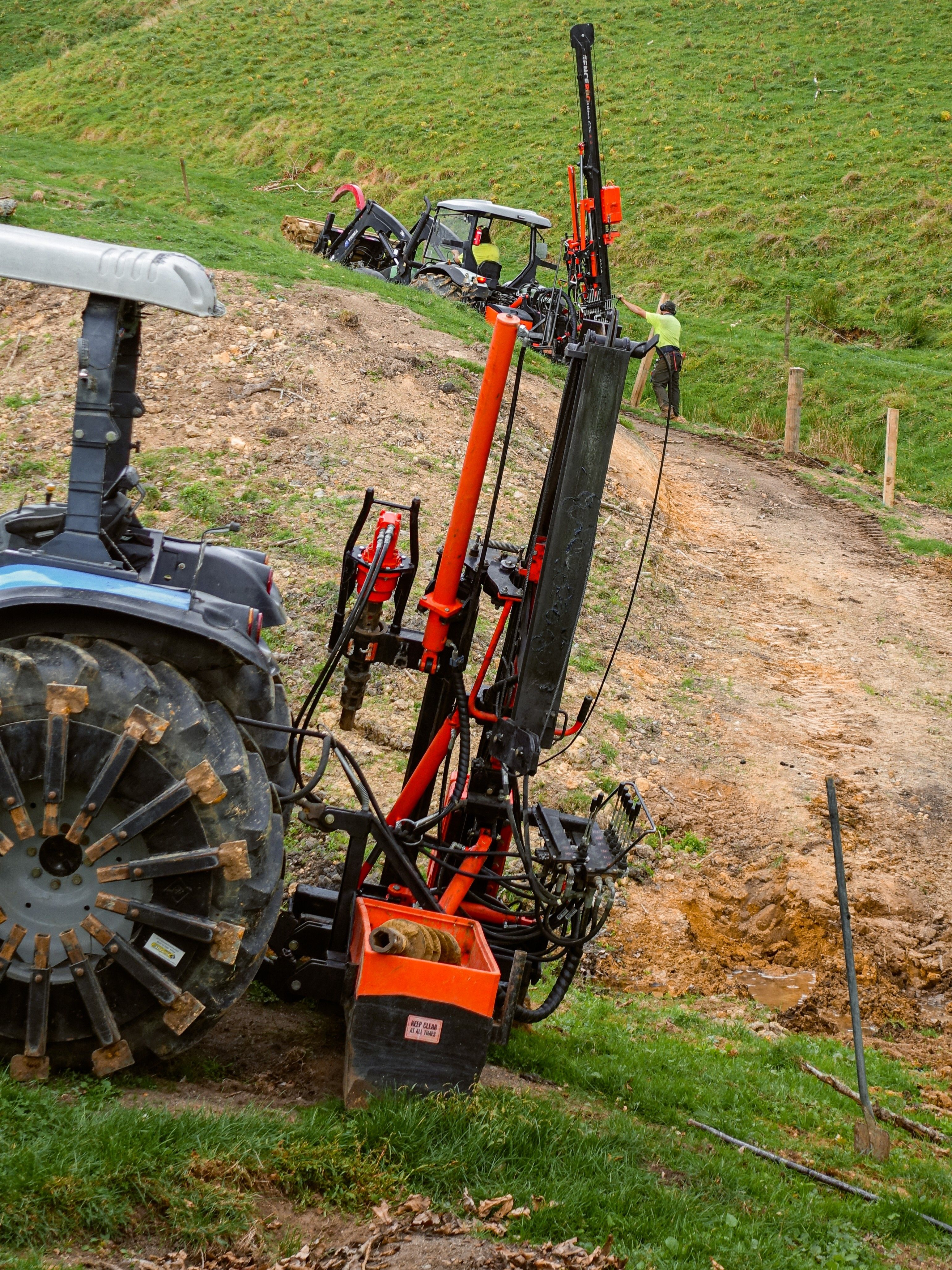 FencePro post driver using rock drill attachment in steep hill country fencing conditions
