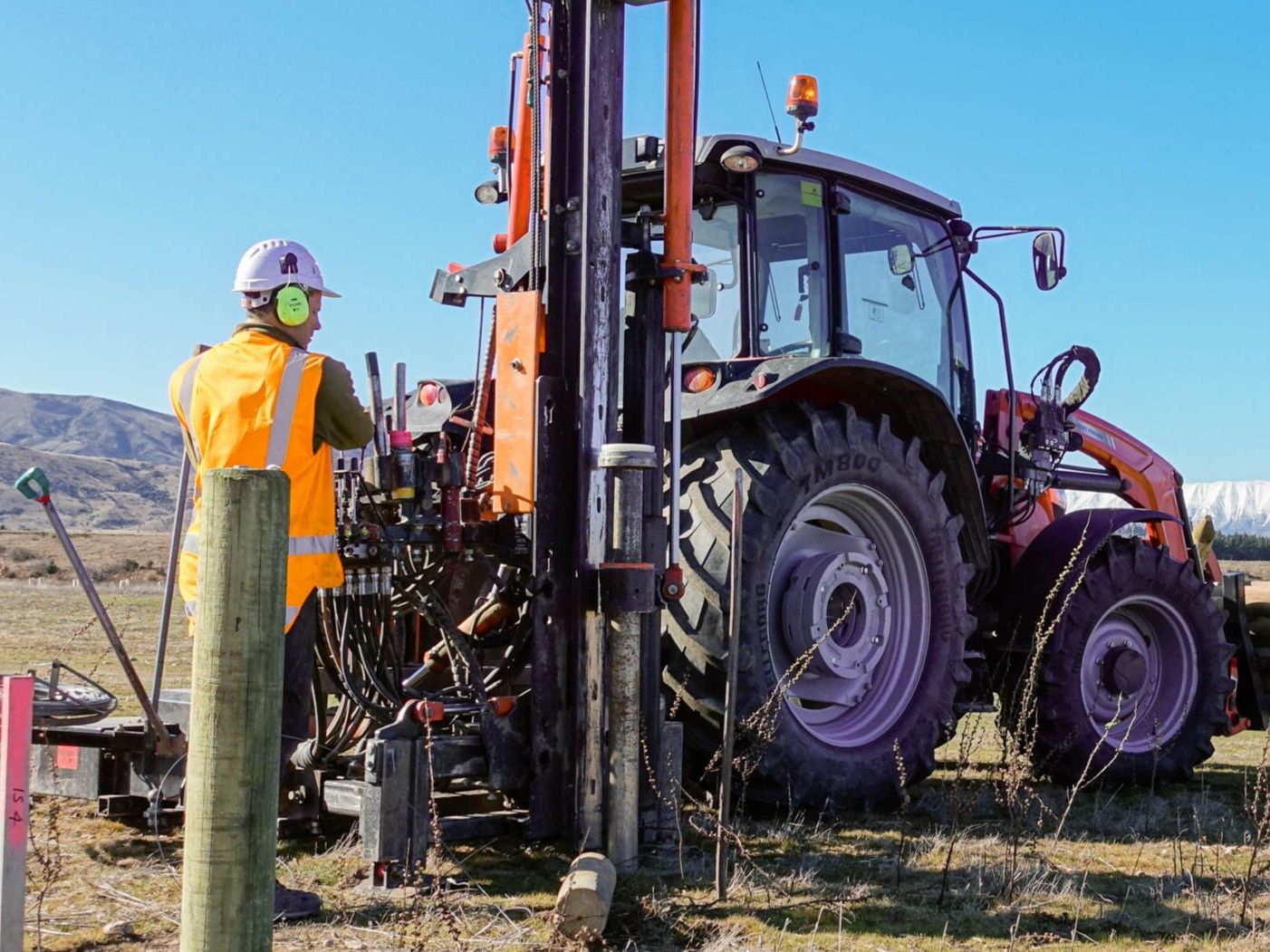 An Otago fencing contractor using the UltraGlide Rock Spike Extractor with the pin & chain profile keeping the rock spike straight to the post driver mast for a straight pilot hole.